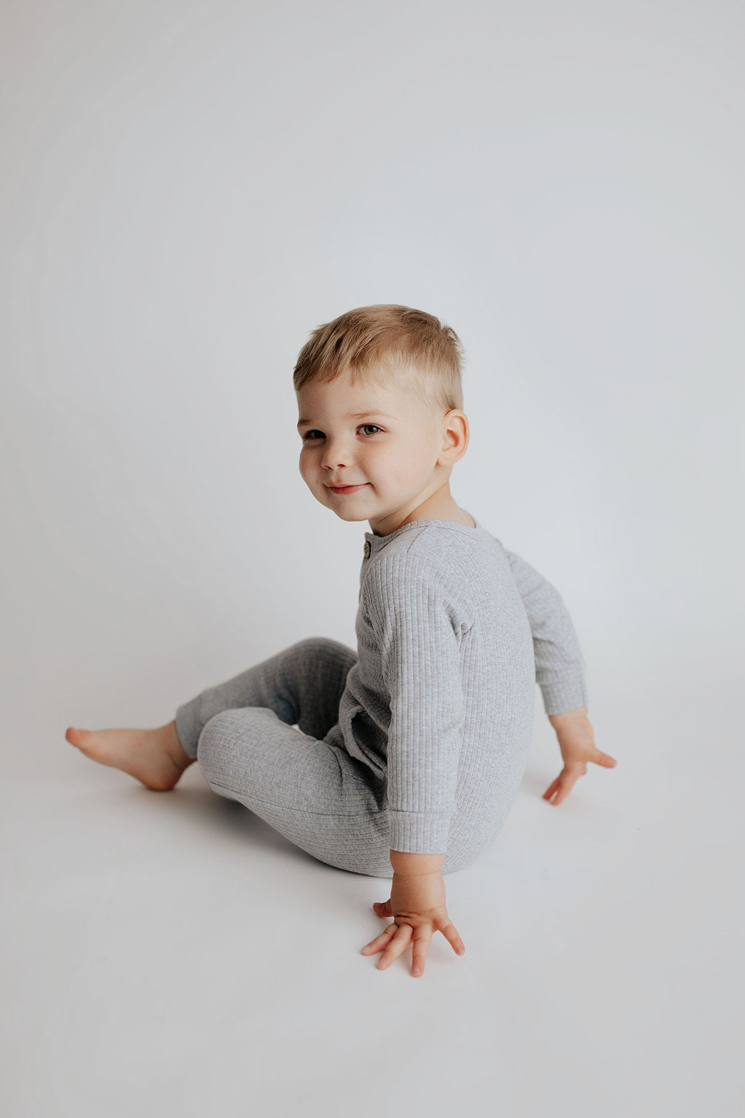 little boy in a Three Little Tots playsuit outfit made with organic cotton