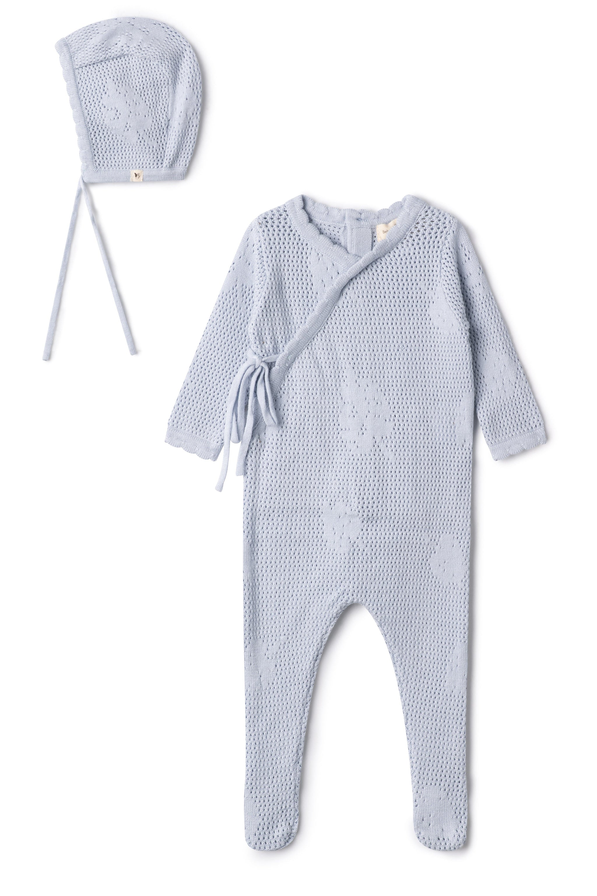 Baby outfit set with knitted romper and bonnet on a white background