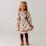 Young girl wearing a floral dress on a plain background