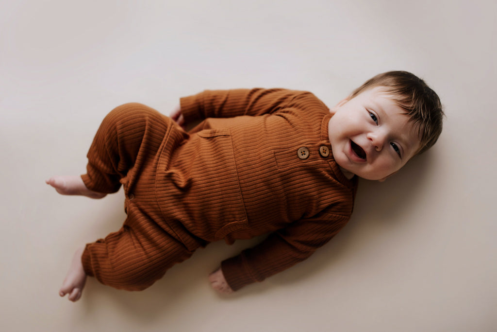 Ribbed long-sleeve onesie with two buttons and leg snaps, crafted from the softest organic cotton blend.