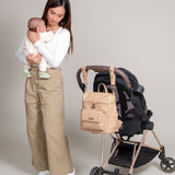 Three Little Tots Petit Diaper Bag Stone Grey, attached to a car seat or stroller