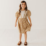 Young girl wearing a floral dress with a white background