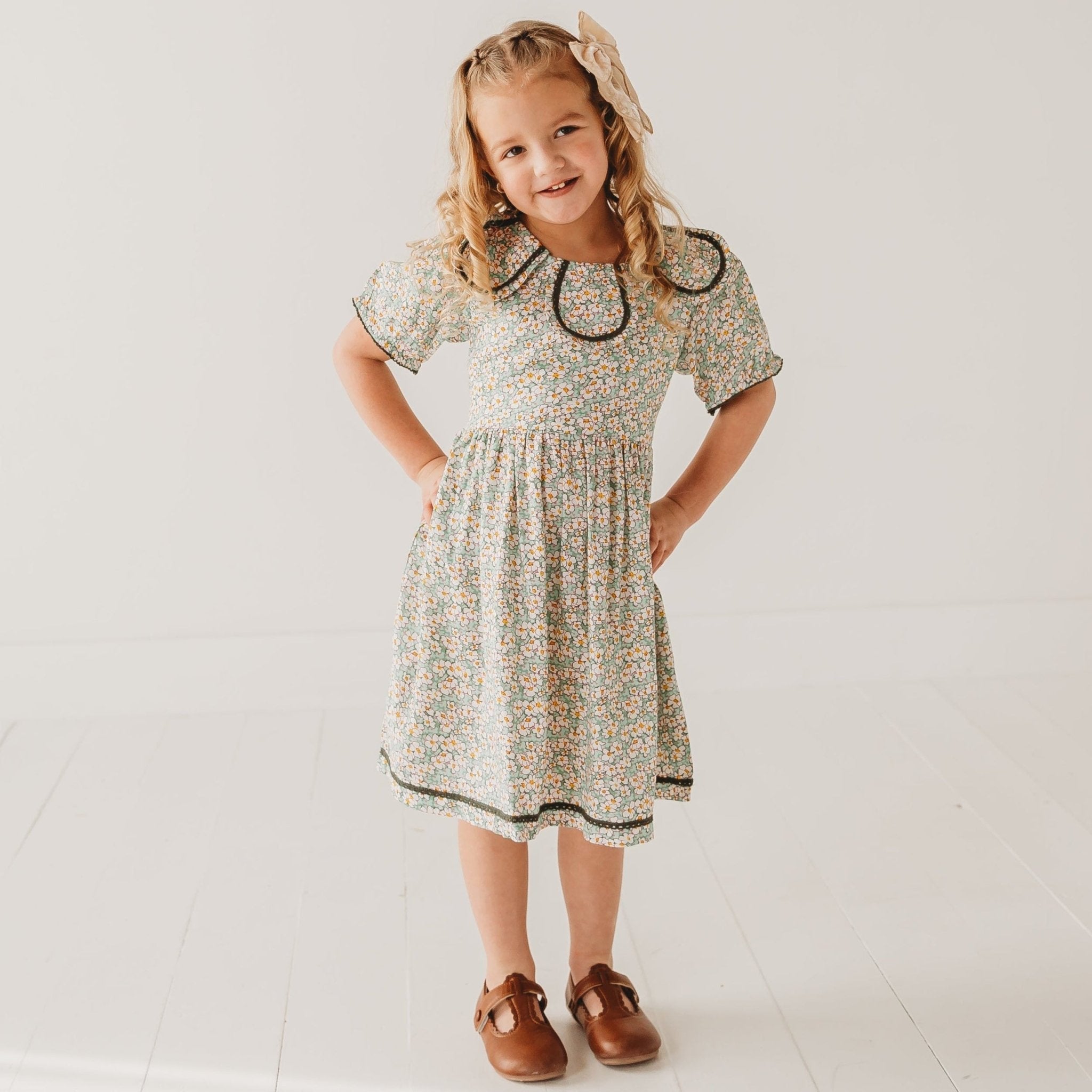 Young girl wearing a floral dress with a white background