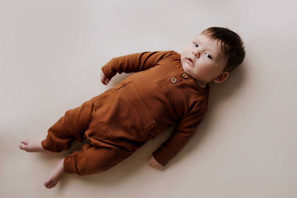 Ribbed long-sleeve onesie with two buttons and leg snaps, crafted from the softest organic cotton blend.