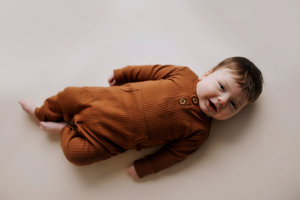 Ribbed long-sleeve onesie with two buttons and leg snaps, crafted from the softest organic cotton blend.