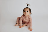 Luxuriously soft ribbed long-sleeve onesie with leg snaps, perfect for lounging and exploring in organic cotton.
