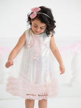 Young girl wearing a sparkling pink dress with a white background