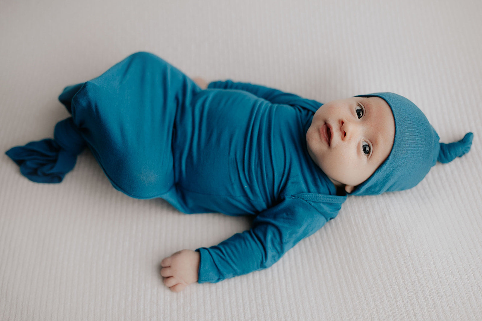 Enhance your newborn photoshoot with cute knotted gowns, perfect for creating heartwarming and memorable baby photos.