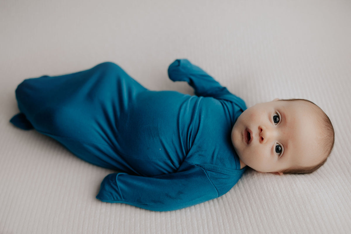 Enhance your newborn photoshoot with cute knotted gowns, perfect for creating heartwarming and memorable baby photos.