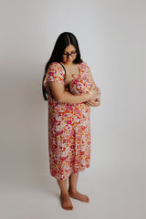 Mom breastfeeding a newborn baby girl. Mom wearing a Three Little Tots Labor & Delivery Gown and the baby wearing the Three Little Tots Wild Child Knotted Gown