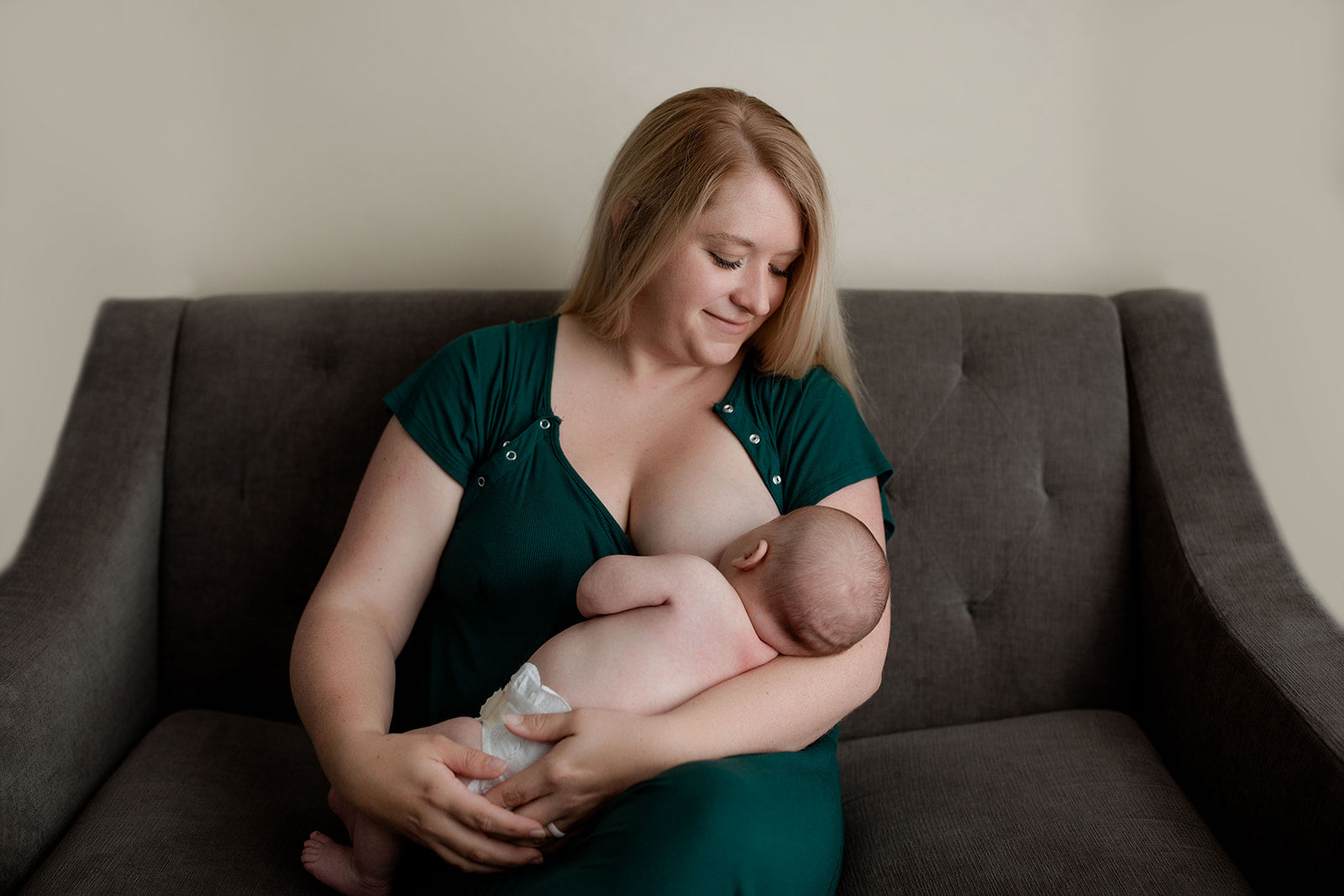 Mom breastfeeding on couch with a Three Little Tots Mommy Gown
