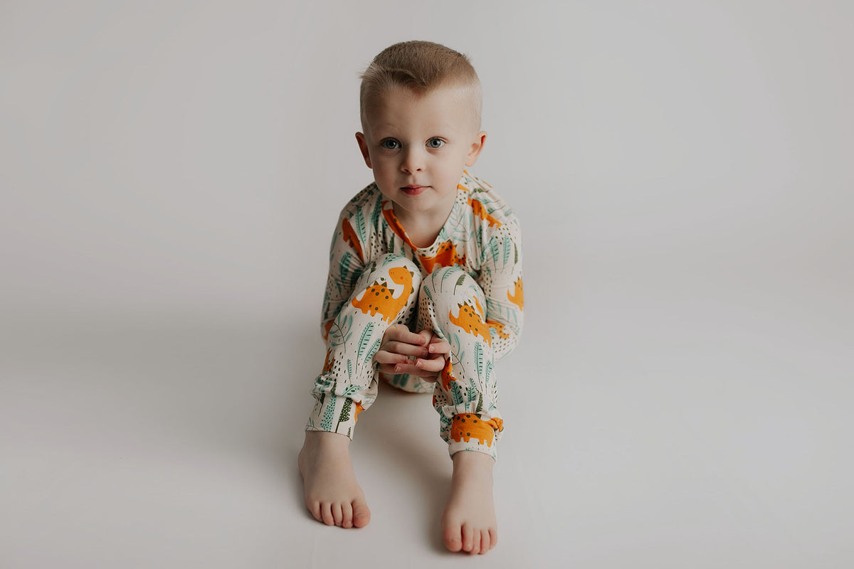 Toddler and big kid jammies in matching prints and solids, designed for comfy bedtime or lounging all day. Dinosaur themed Kids Pajamas.