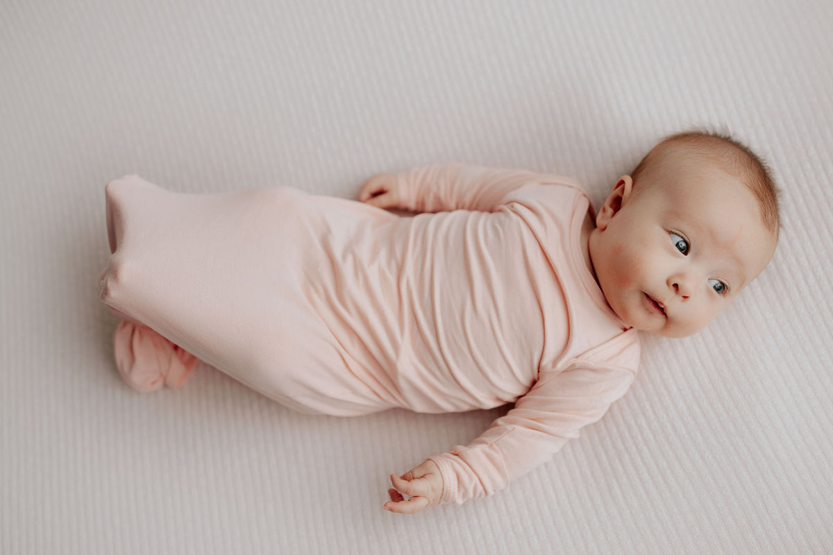Newborn photoshoot featuring the Three Little Tots Heavenly Pink Knotted Baby Gown