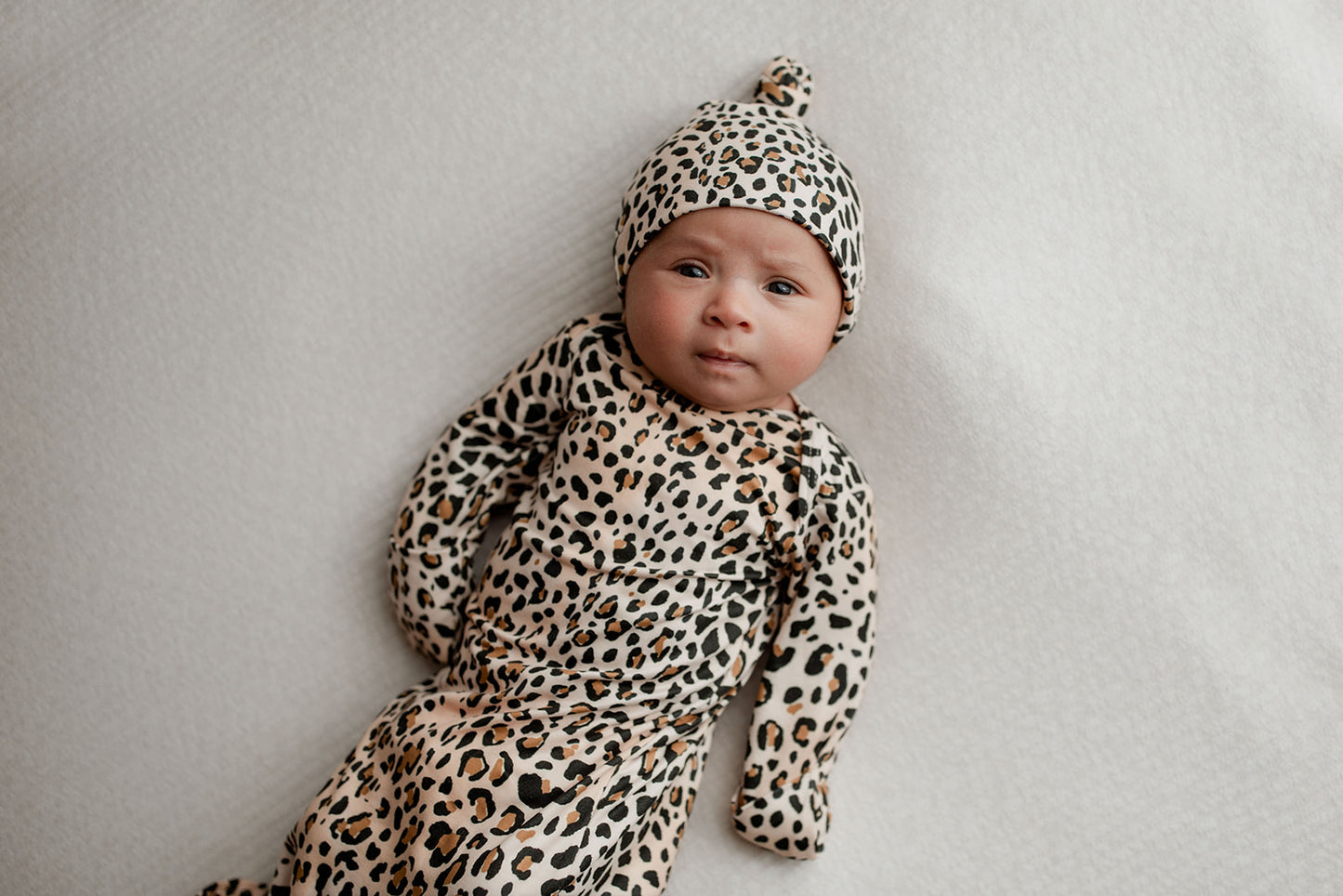 Three Little Tots Knotted baby gown features fold over mittens and a tie bottom that mimics the womb to bring comfort to newborns.