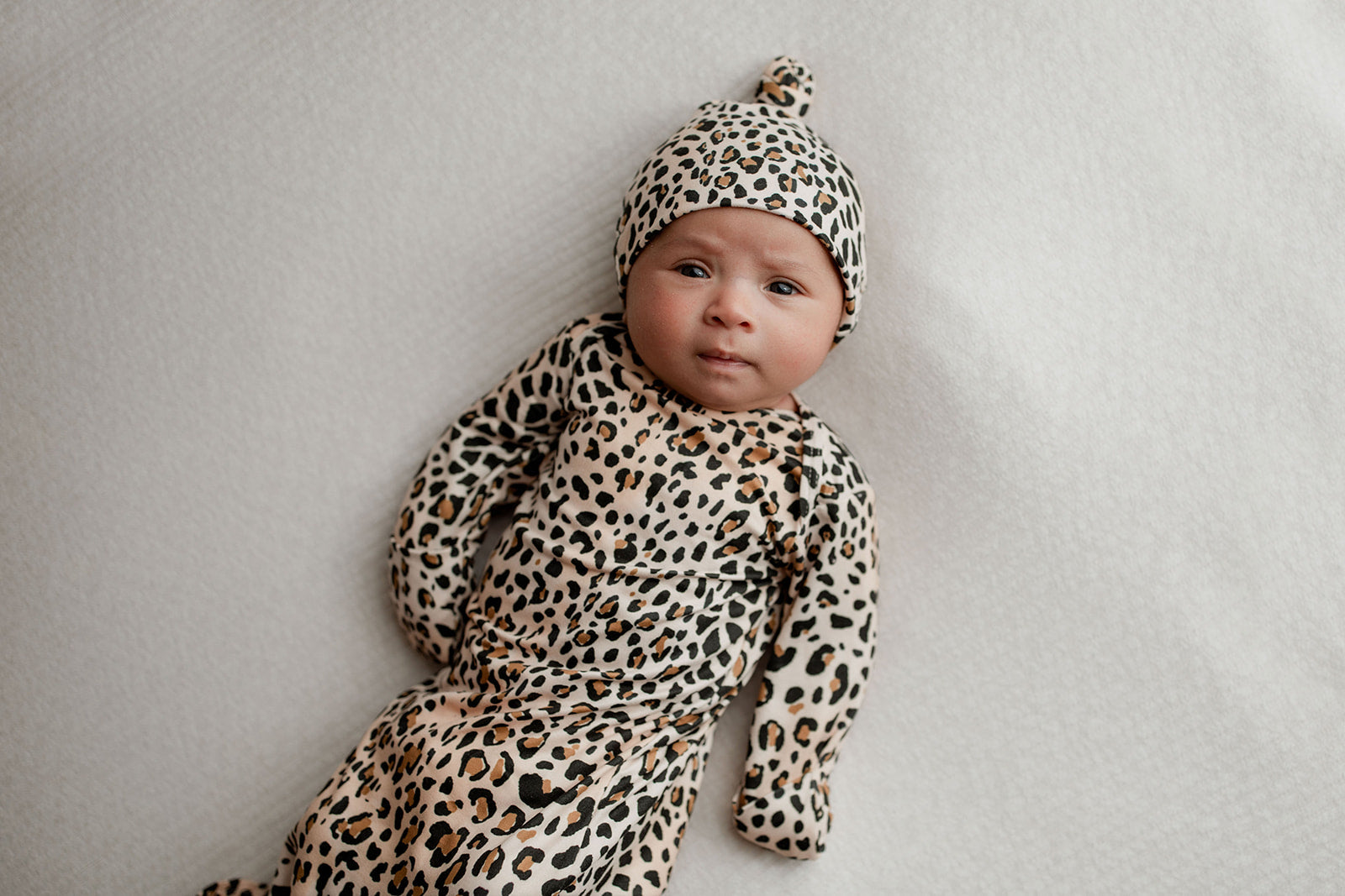 Three Little Tots Knotted baby gown features fold over mittens and a tie bottom that mimics the womb to bring comfort to newborns.