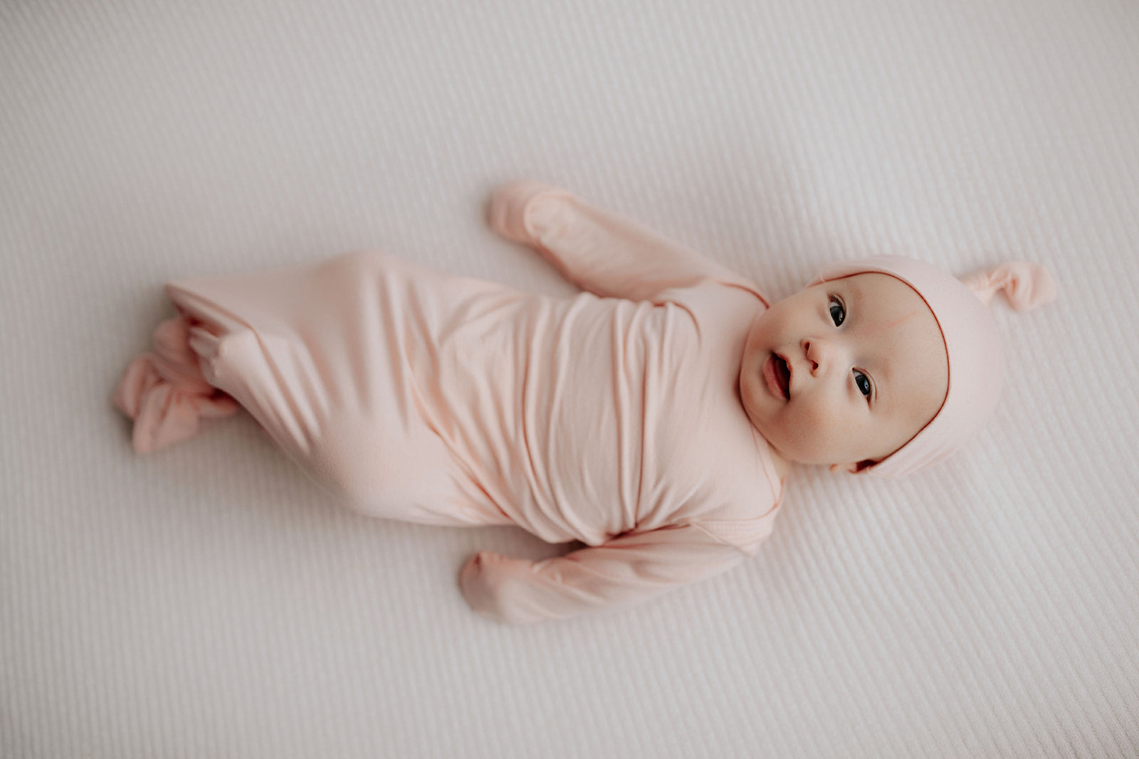 adorable newborn baby girl photoshoot in a Three Little Tots heavenly Pink knotted baby gown