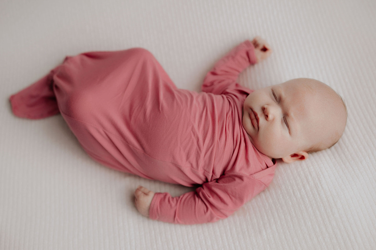 Luxuriously soft modal knotted baby gowns for newborn babies, offering comfort, easy diaper changes, and style. Three Little Tots Rose Pink Knotted baby gown. Knotted tie bottom mimics the womb to bring comfort to your newborn. 