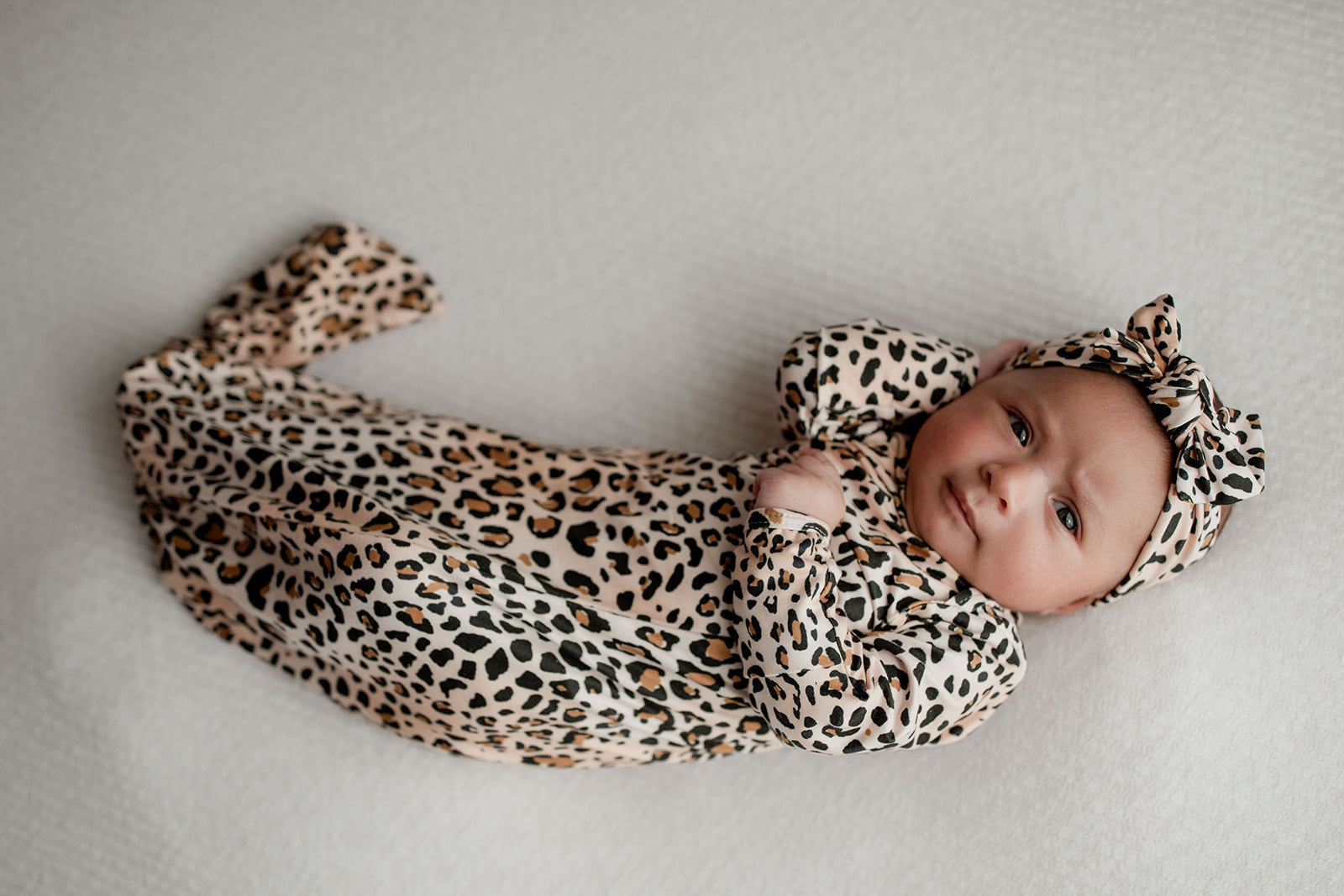 A newborn photoshoot idea with the Leopard Three Little Tots knotted baby gown with a cute bow.