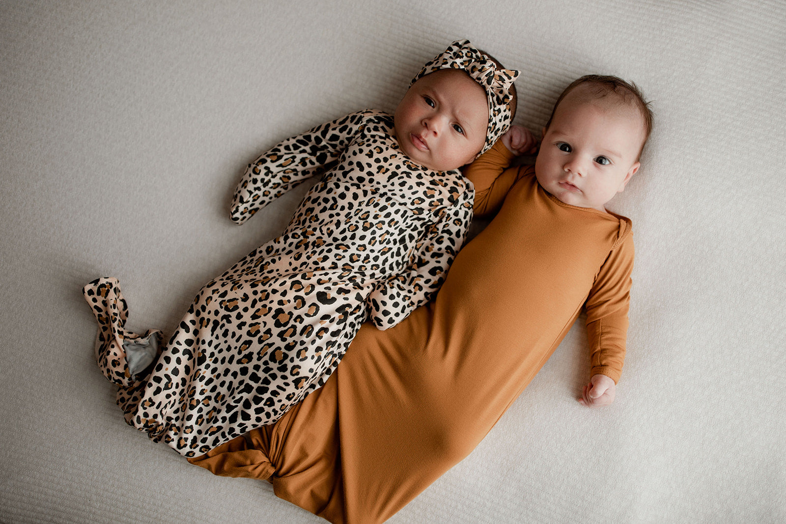 Three Little Tots Knotted baby gown features fold over mittens and a tie bottom that mimics the womb to bring comfort to newborns.