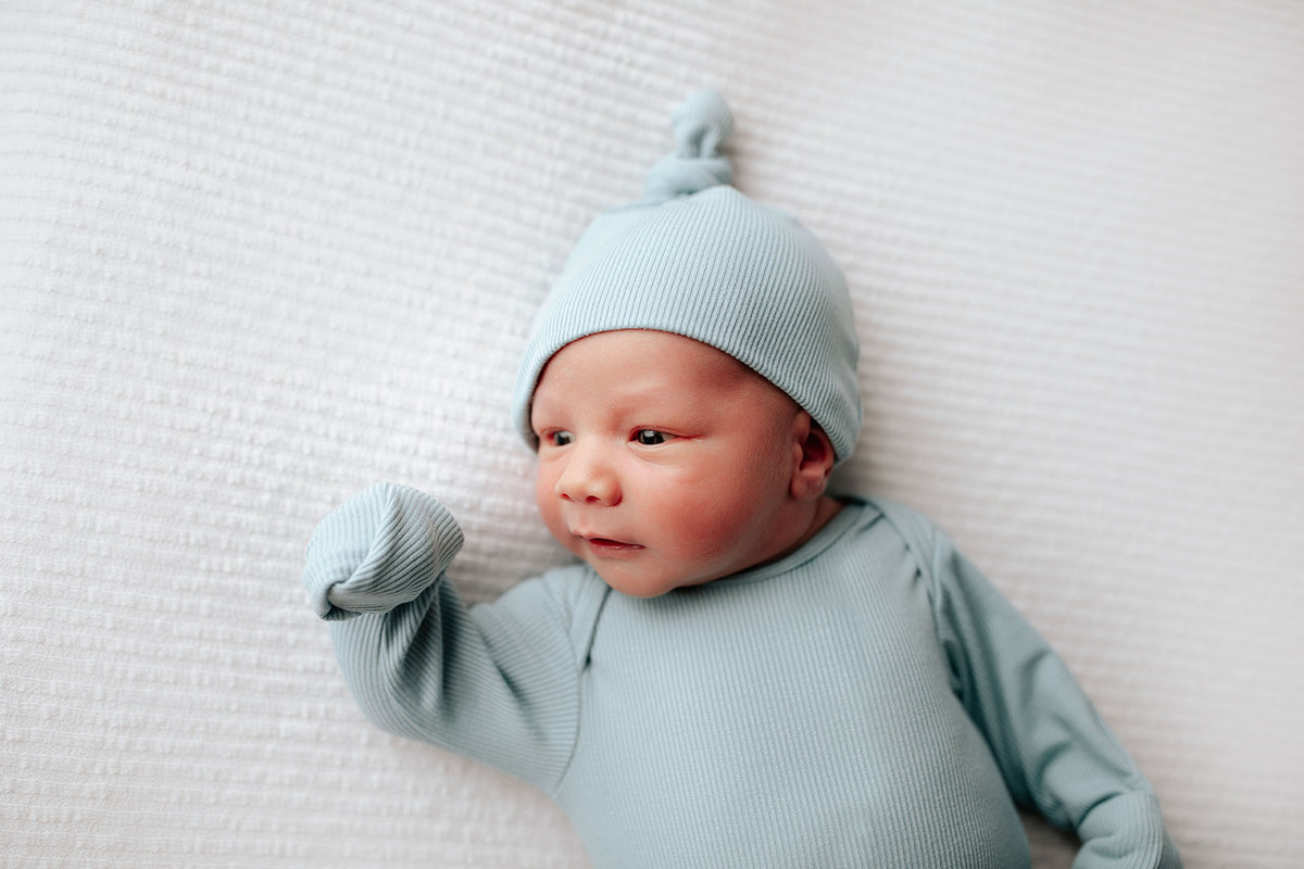 knotted blue baby gown with fold over mittens. Simplify diaper changes with a tie-bottom outfit featuring a button-down front and fold-over wrist cuffs.