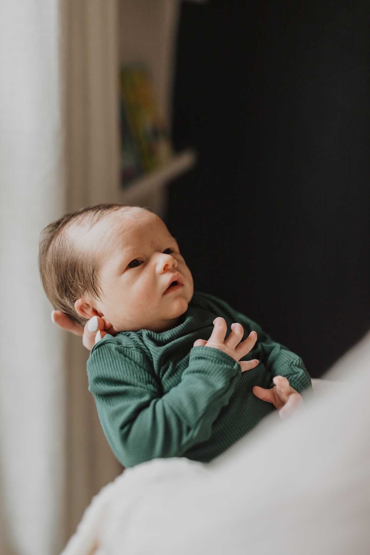 Newborn family photoshoot. Baby is wearing Three Little Tots Forest Green Knotted Gown