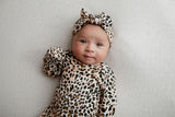 A newborn photoshoot idea with the Leopard Three Little Tots knotted baby gown with a cute bow. Showcasing the fold over mittens.