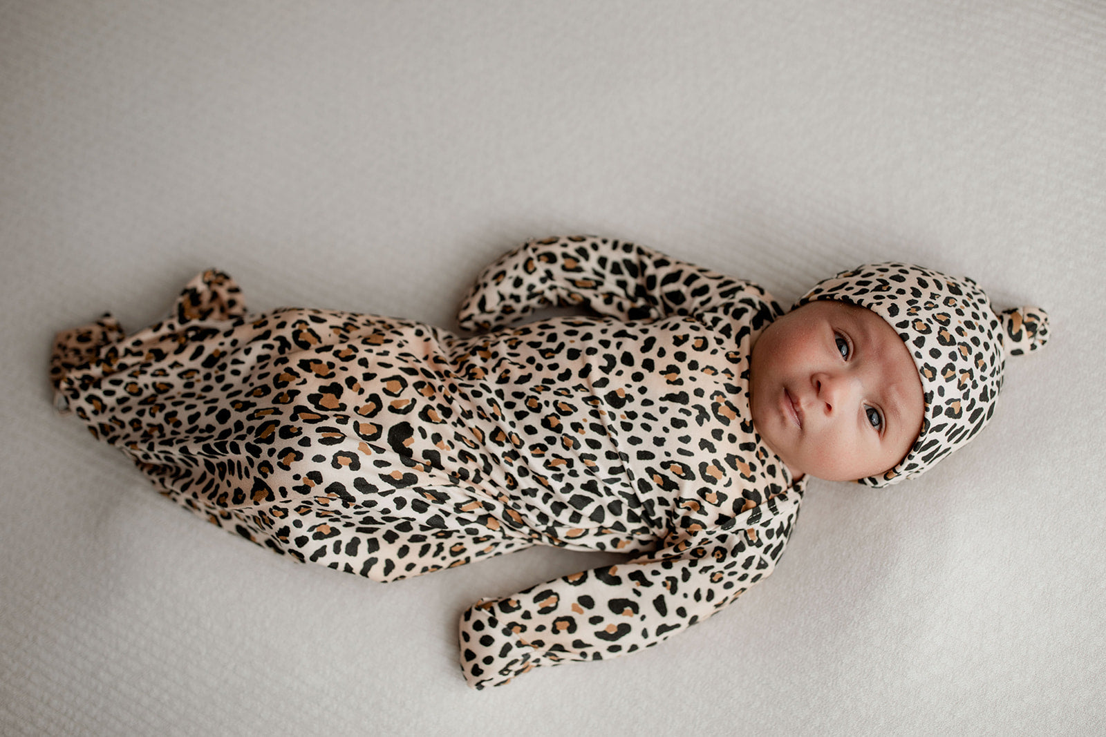 Three Little Tots Knotted baby gown features fold over mittens and a tie bottom that mimics the womb to bring comfort to newborns.
