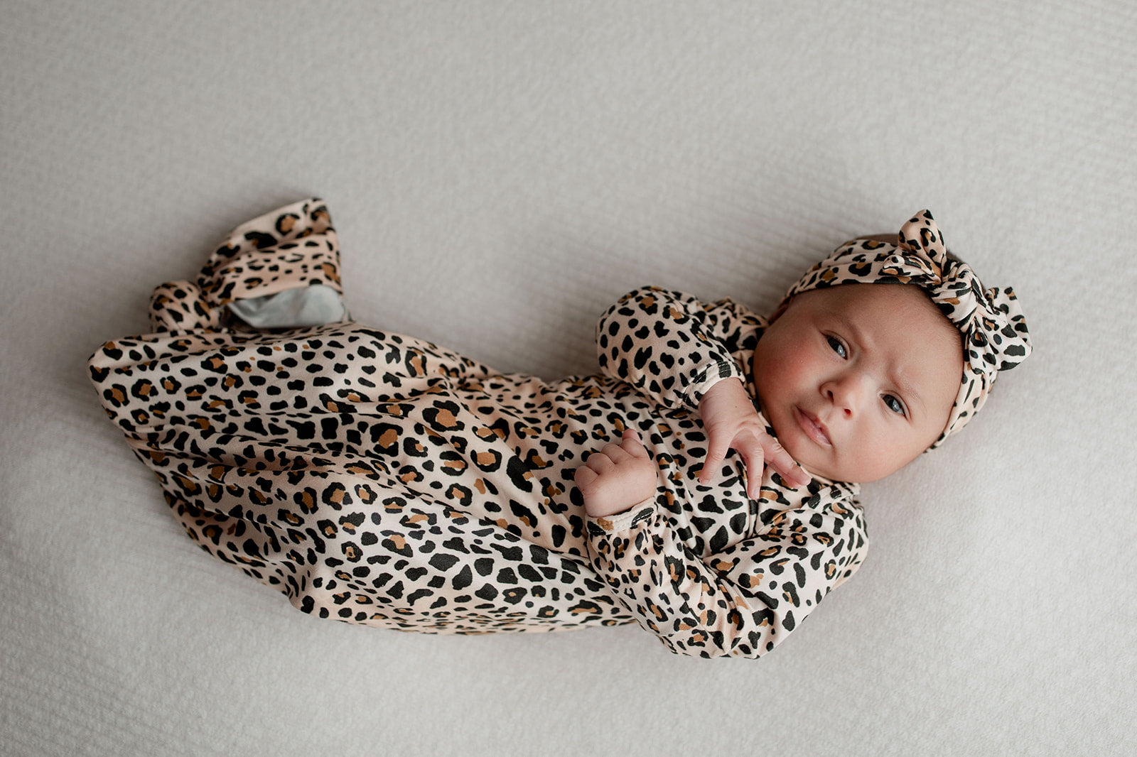 A newborn photoshoot idea with the Leopard Three Little Tots knotted baby gown with a cute bow.