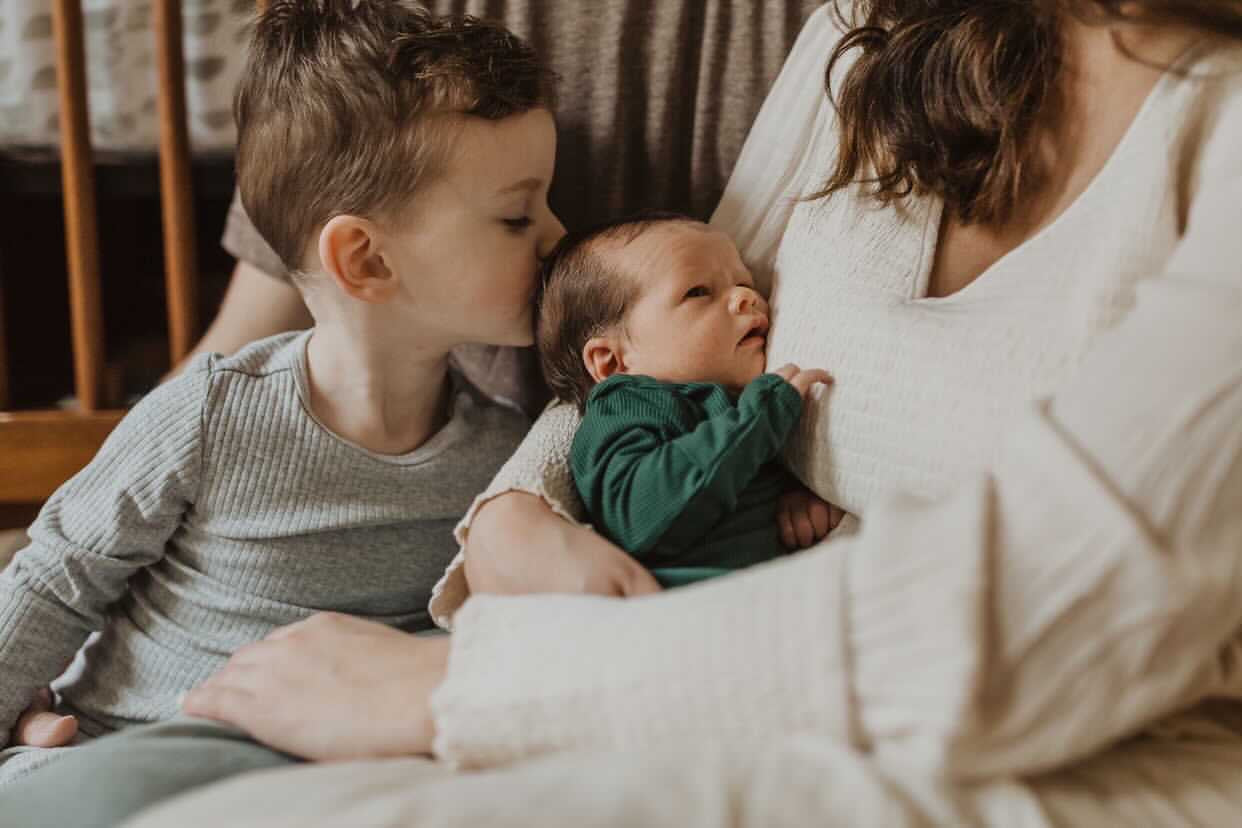 Newborn family photoshoot. Baby is wearing Three Little Tots Forest Green Knotted Gown