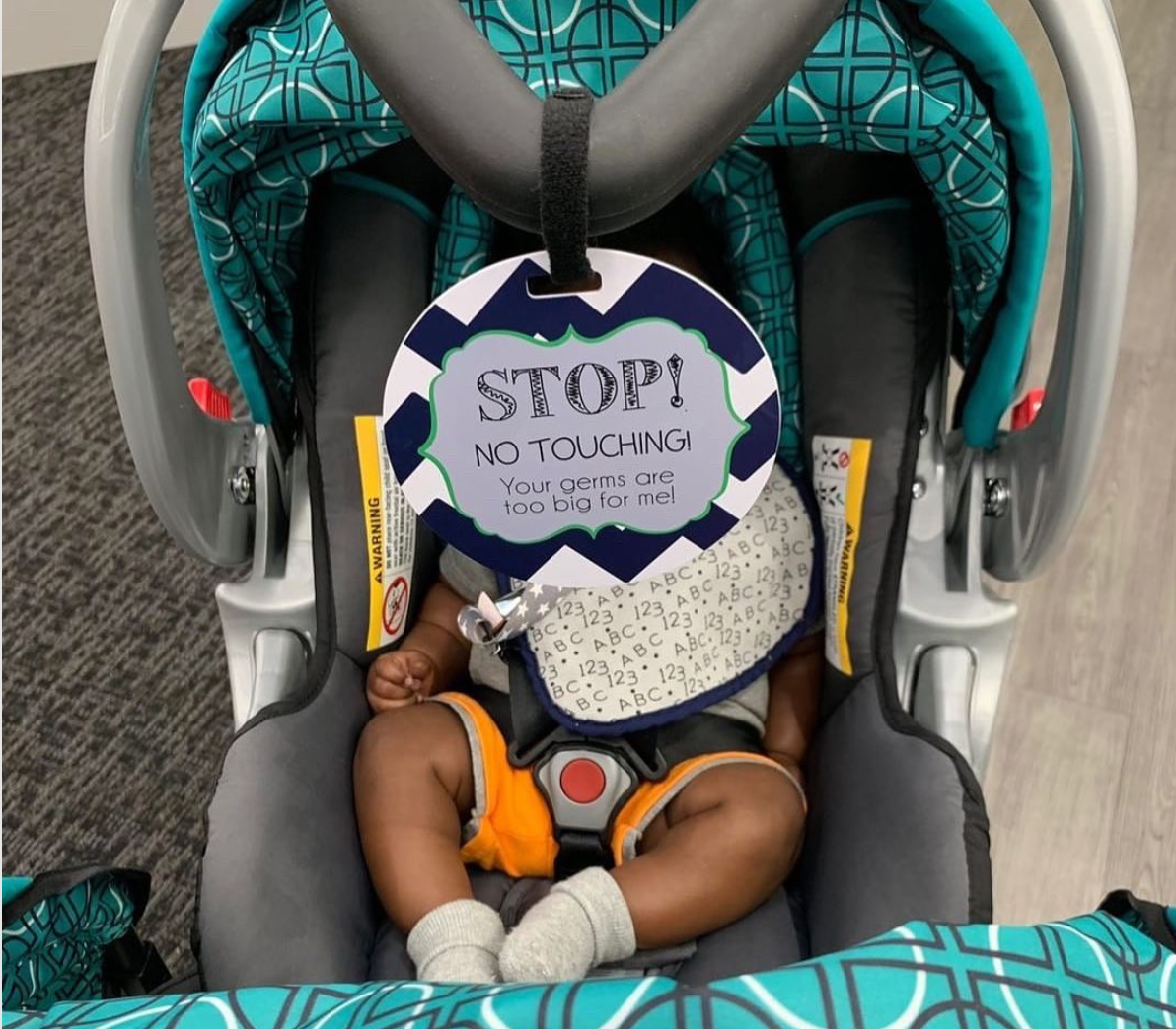 Three Little Tots No Touching Baby Sign on a newborn car seat with little boy.