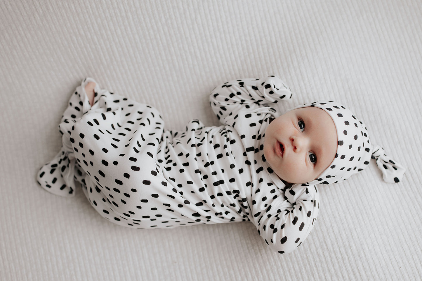 newborn baby in a Three Little Tots polka dot knotted baby gown