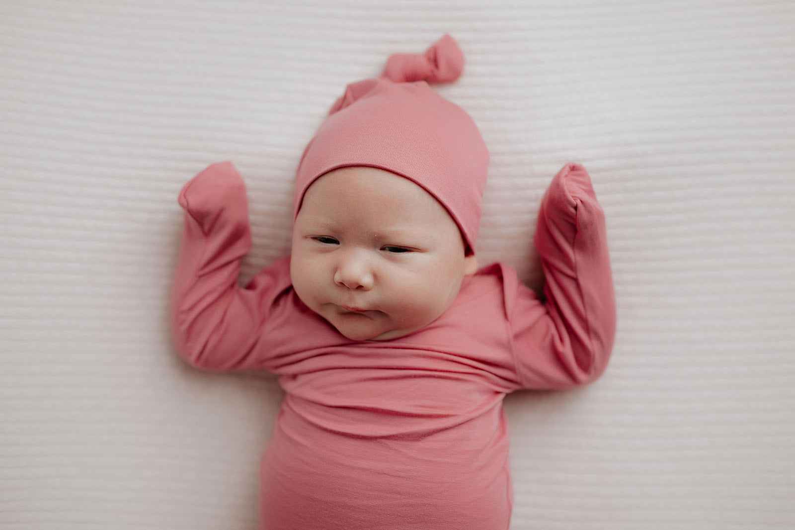 Luxuriously soft modal knotted baby gowns for newborn babies, offering comfort, easy diaper changes, and style. Three Little Tots Rose Pink Knotted baby gown. Knotted tie bottom mimics the womb to bring comfort to your newborn