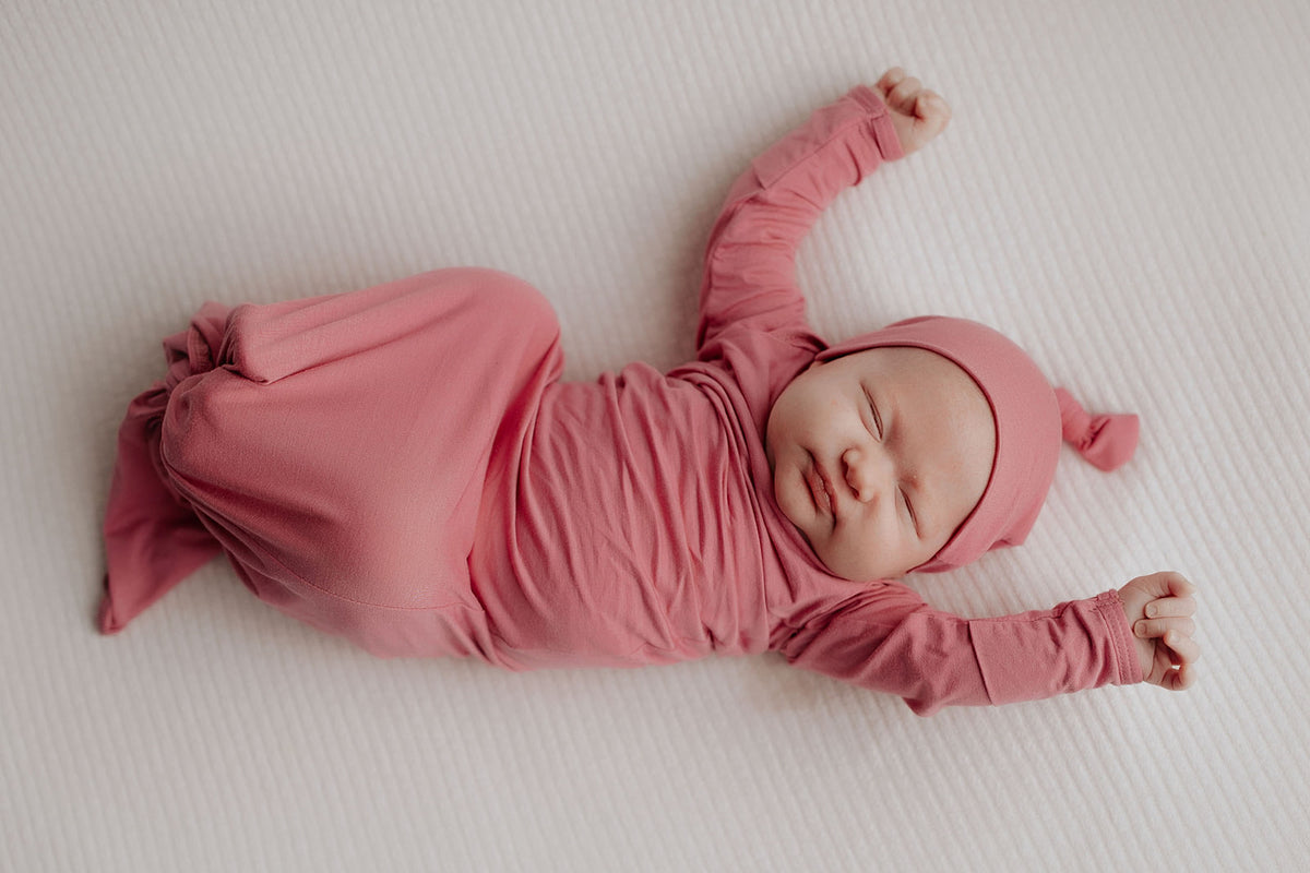 Luxuriously soft modal knotted baby gowns for newborn babies, offering comfort, easy diaper changes, and style. Three Little Tots Rose Pink Knotted baby gown. Knotted tie bottom mimics the womb to bring comfort to your newborn