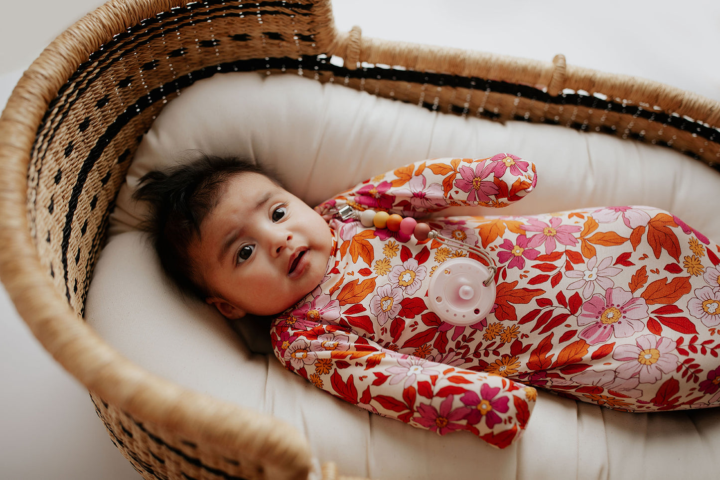 The cutest pink floral design for a newborn knotted baby gown. Trust in our knotted baby gowns, providing unparalleled comfort and ease for your baby's delicate skin. Snuggle Me organics featured in a plum + sparrow moses basket