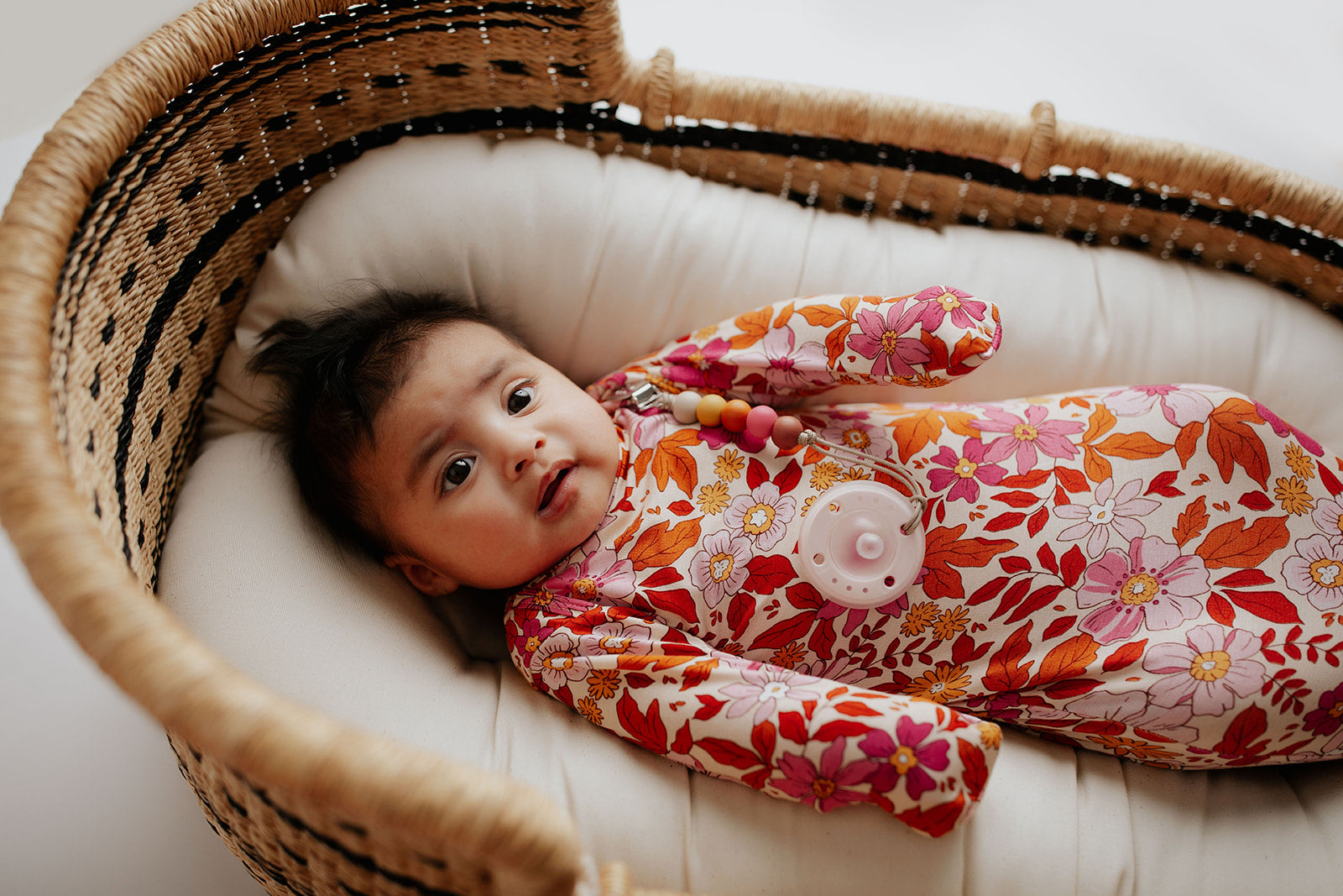 The cutest pink floral design for a newborn knotted baby gown. Trust in our knotted baby gowns, providing unparalleled comfort and ease for your baby's delicate skin. Snuggle Me organics featured in a plum + sparrow moses basket