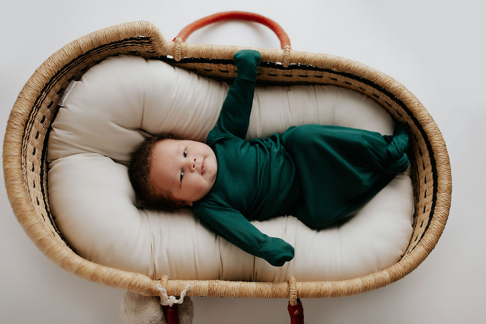 Ultra-soft baby gowns with tie bottoms for easy nighttime changes and pull-down tabs for effortless dressing. Perfect for a Christmas baby. Shown in a SnuggleMe organics in a Plum + Sparrow Moses Basket