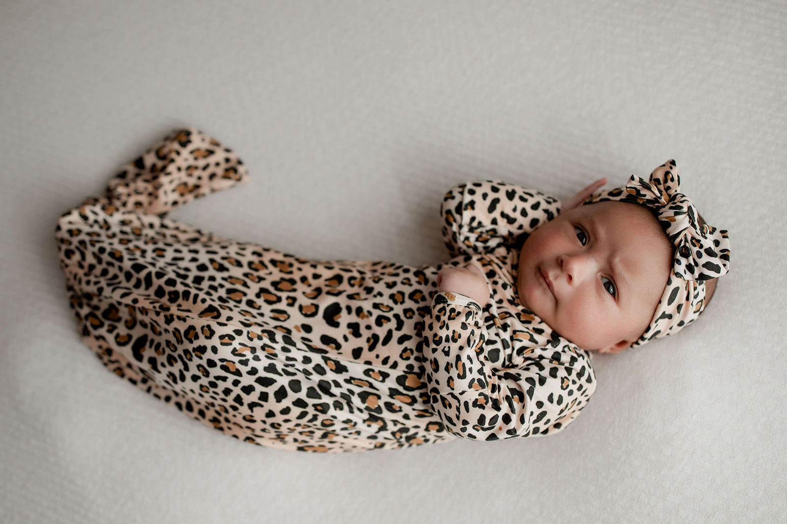 A newborn photoshoot idea with the Leopard Three Little Tots knotted baby gown with a cute bow.