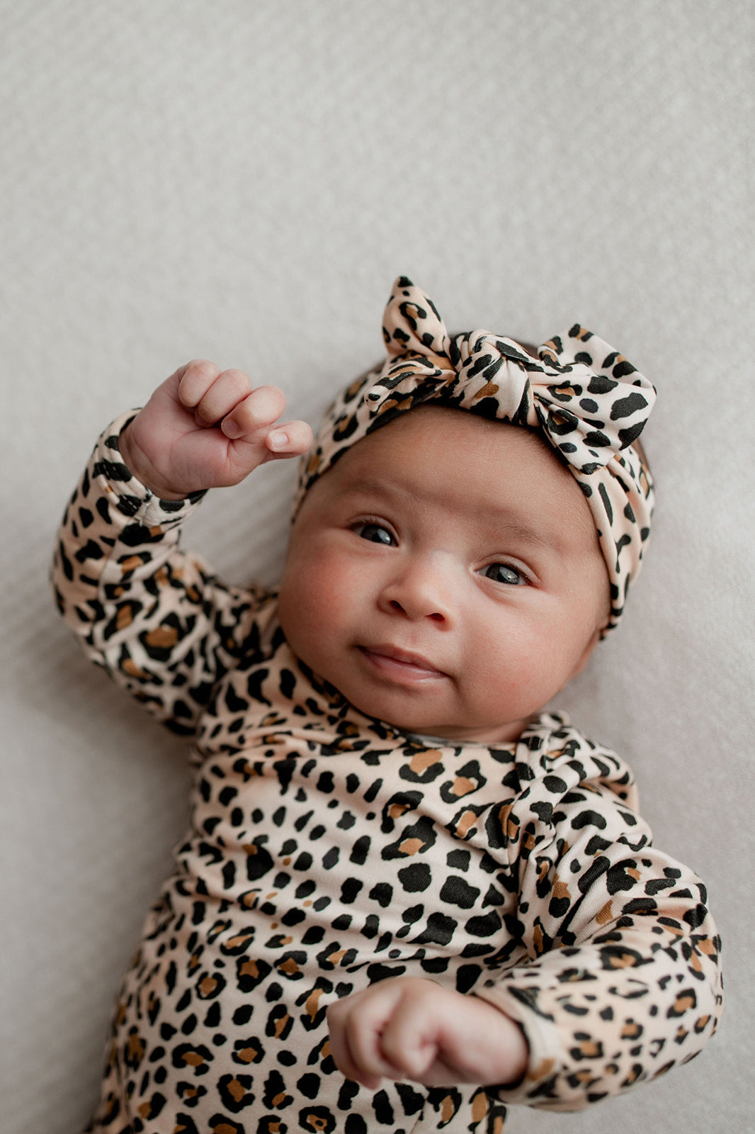 A newborn photoshoot idea with the Leopard Three Little Tots knotted baby gown with a cute bow.