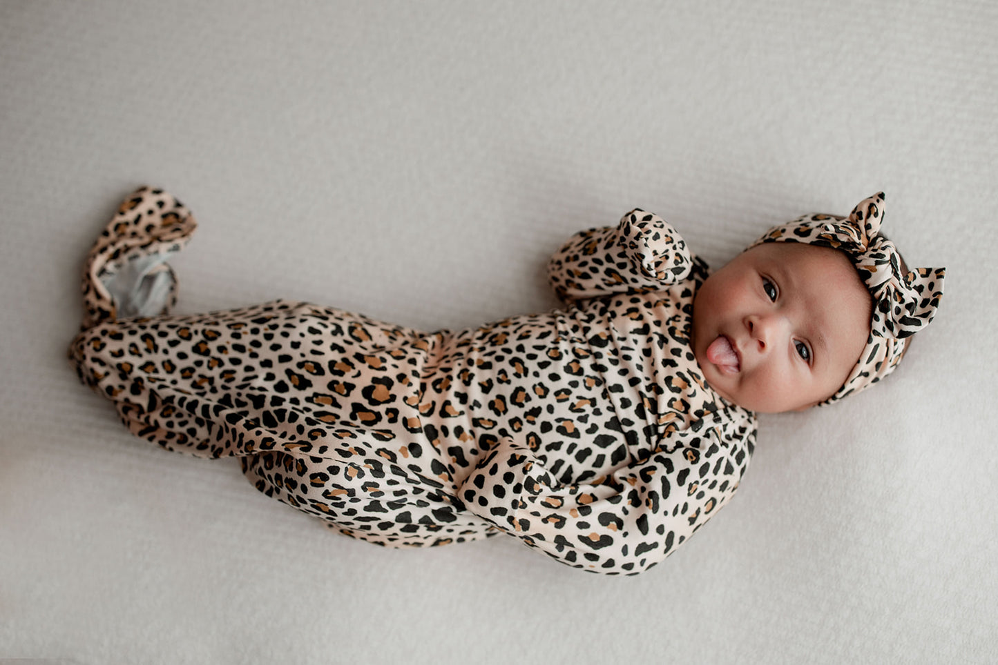 Three Little Tots Knotted baby gown features fold over mittens and a tie bottom that mimics the womb to bring comfort to newborns.