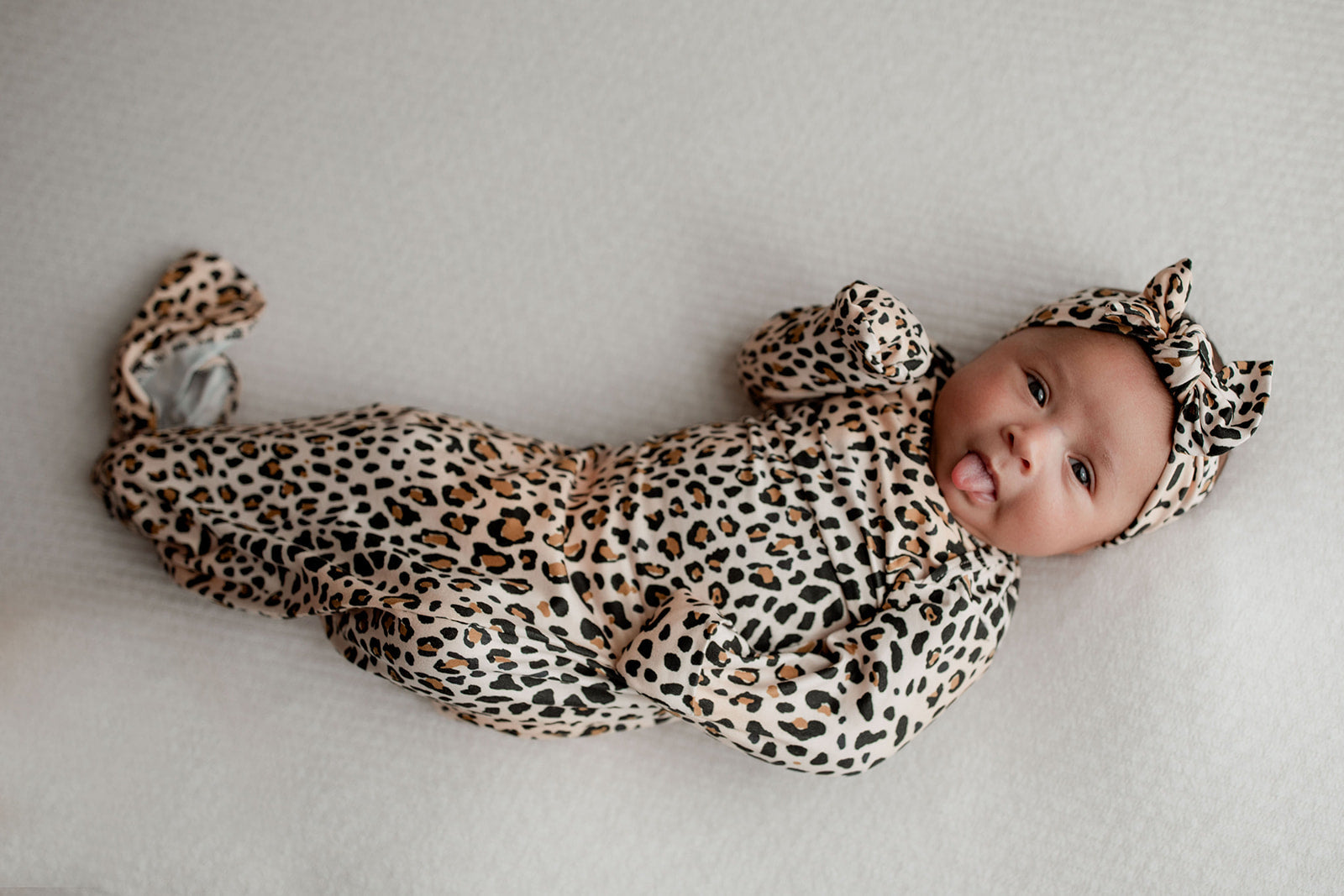 Three Little Tots Knotted baby gown features fold over mittens and a tie bottom that mimics the womb to bring comfort to newborns.
