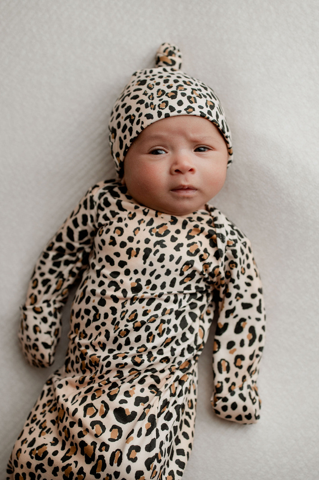 Three Little Tots Knotted baby gown features fold over mittens and a tie bottom that mimics the womb to bring comfort to newborns.