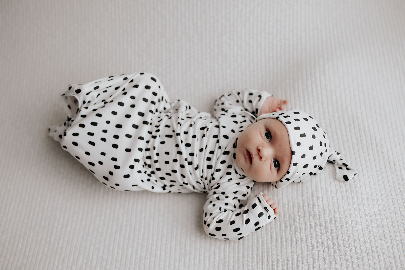 newborn baby in a Three Little Tots polka dot knotted baby gown