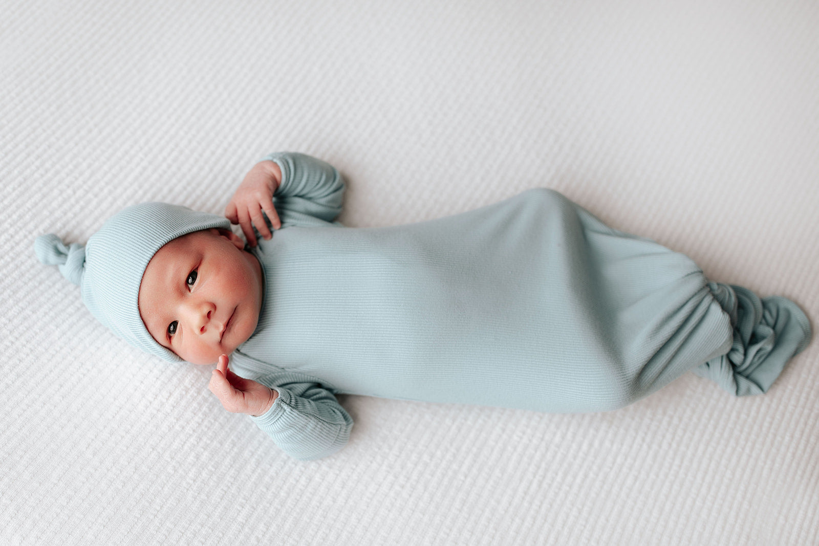 Simplify diaper changes with a tie-bottom outfit featuring a button-down front and fold-over wrist cuffs.