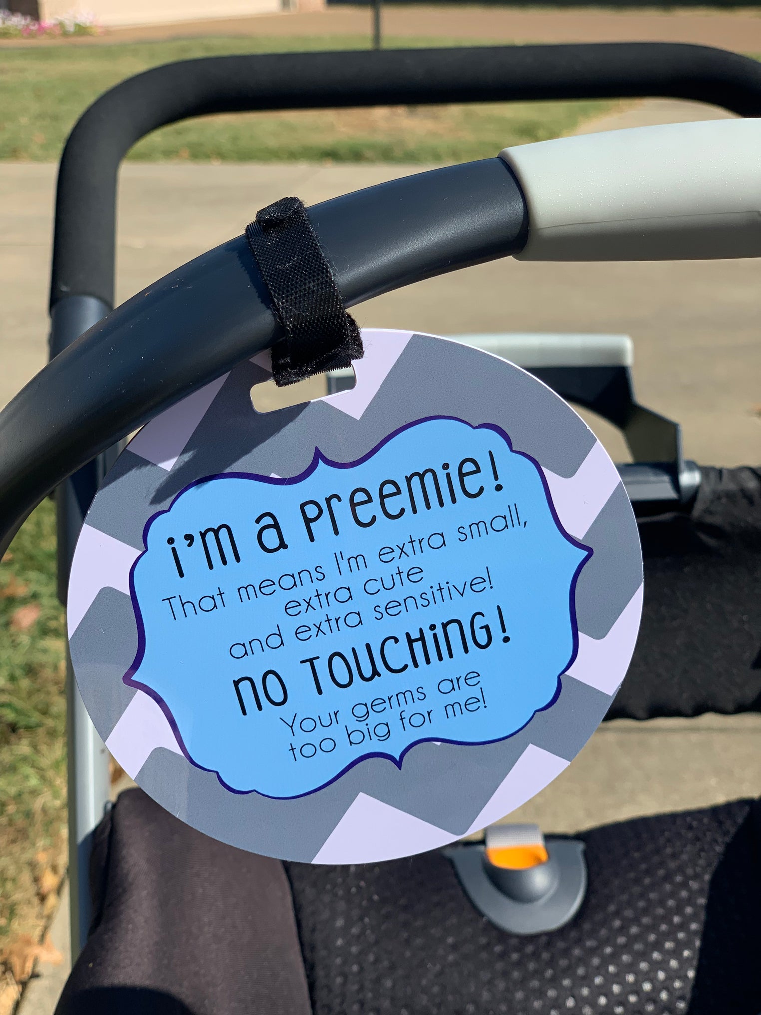 Three Little Tots Preemie No touching baby car seat sign on a stroller