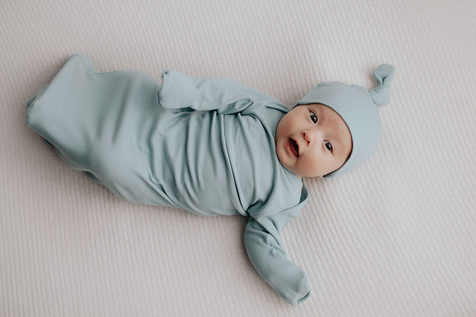 Enjoy hassle-free diaper changes with a button-down front, tie bottom, and fold-over wrist cuffs.