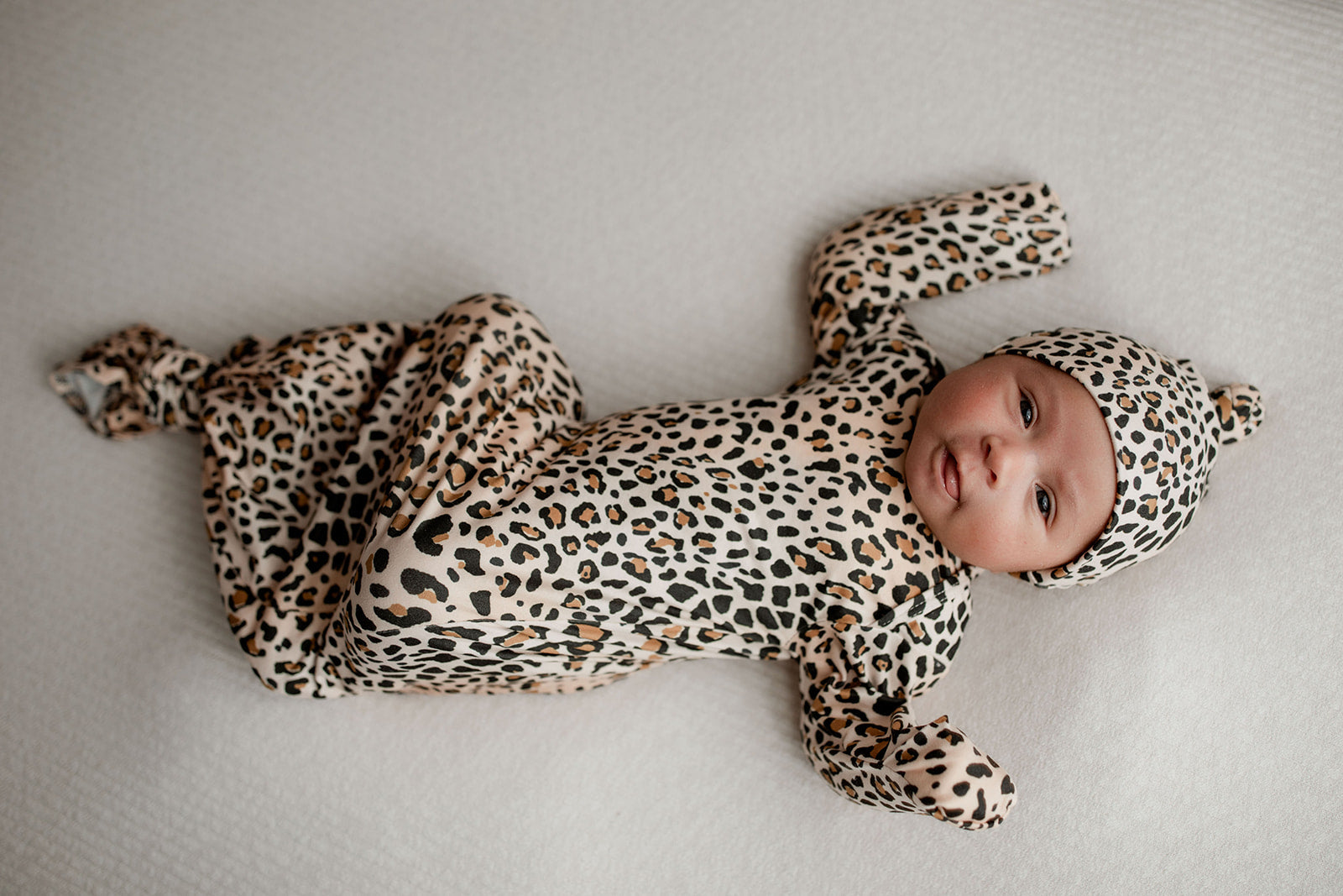 Three Little Tots Knotted baby gown features fold over mittens and a tie bottom that mimics the womb to bring comfort to newborns.