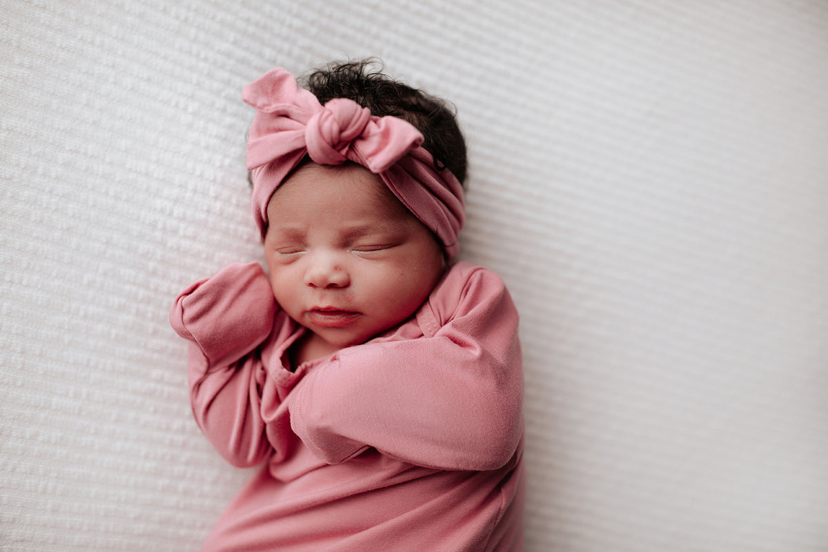 Luxuriously soft modal knotted baby gowns for newborn babies, offering comfort, easy diaper changes, and style. Three Little Tots Rose Pink Knotted baby gown. Knotted tie bottom mimics the womb to bring comfort to your newborn