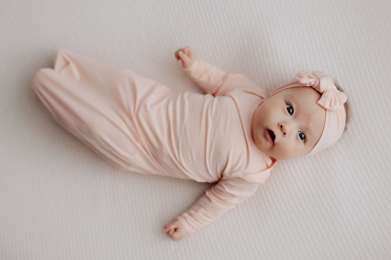 cute photo of a newborn with the Three Little Tots heavenly pink knotted baby gown