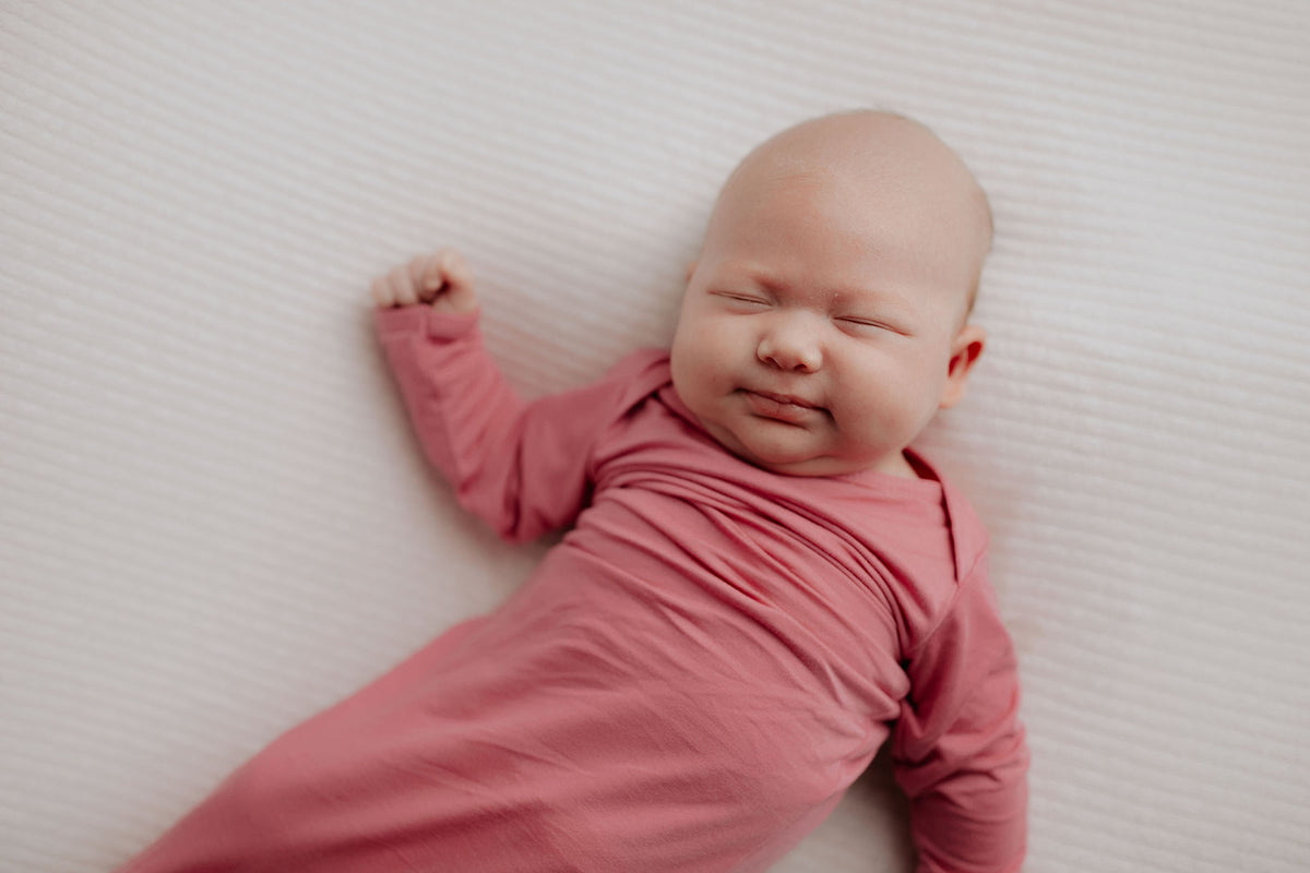 Luxuriously soft modal knotted baby gowns for newborn babies, offering comfort, easy diaper changes, and style. Three Little Tots Rose Pink Knotted baby gown. Knotted tie bottom mimics the womb to bring comfort to your newborn