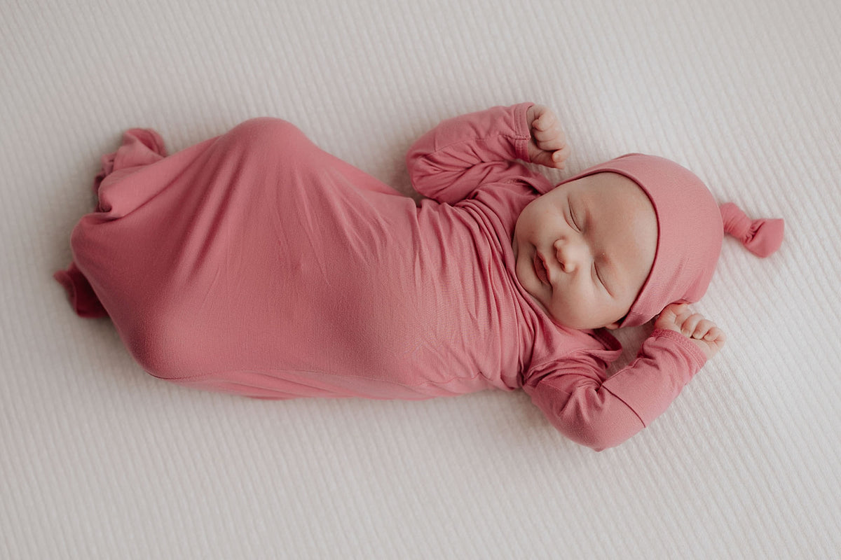 Luxuriously soft modal knotted baby gowns for newborn babies, offering comfort, easy diaper changes, and style. Three Little Tots Rose Pink Knotted baby gown. Knotted tie bottom mimics the womb to bring comfort to your newborn